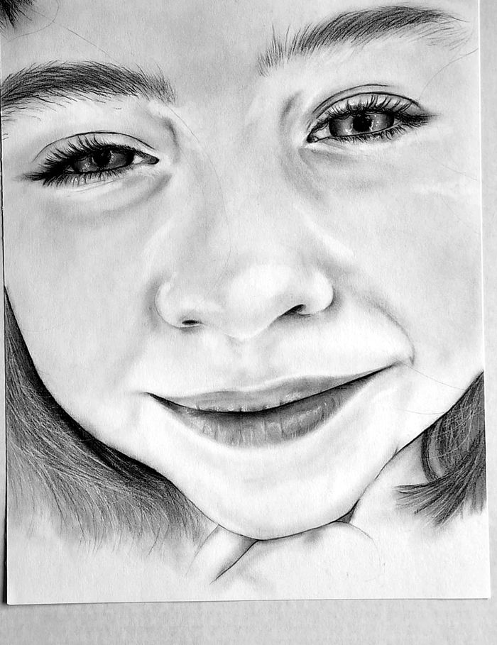 Close-up graphite portrait of a smiling child